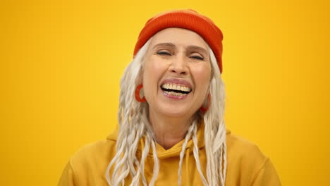 cheerful elderly woman posing in studio. smiling senior lady laughing indoors.