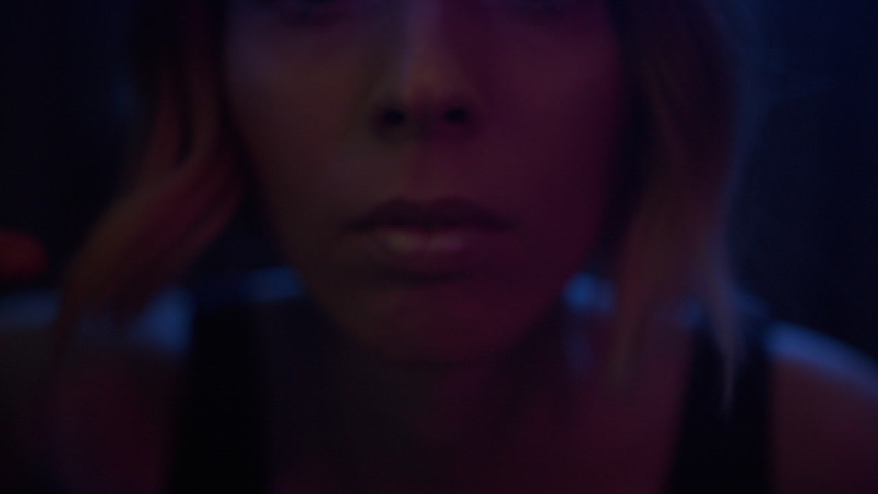 A young woman appears through glittering curtain