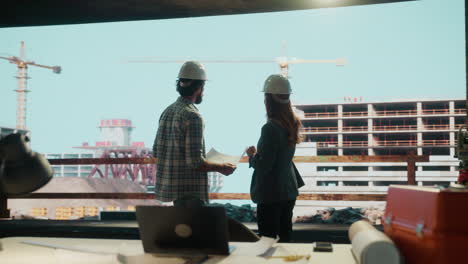 engineers or architects discussing and shaking hands at a construction site