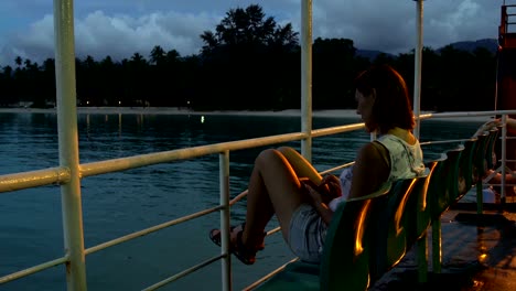 a woman sits in a chair on a ferry