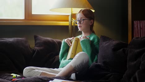 chica leyendo un libro en el sofá