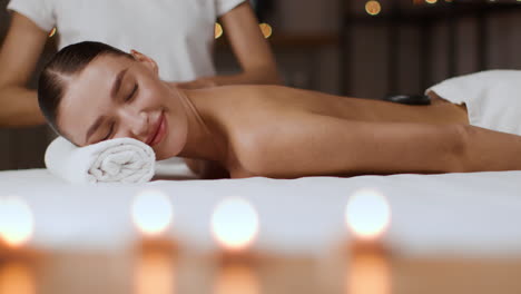 woman enjoying a relaxing hot stone massage at a spa