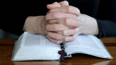 woman praying with bible on table with black background with people stock video