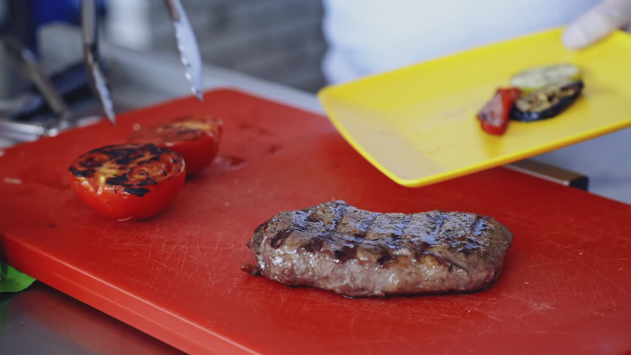 Chef preparing food. Grilled meat with vegetables on board