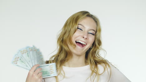 Young-Woman-Counting-Money-Rejoices-Shot-On-A-White-Background-In-The-Studio