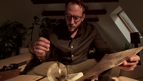 intrigued man examining old documents and maps
