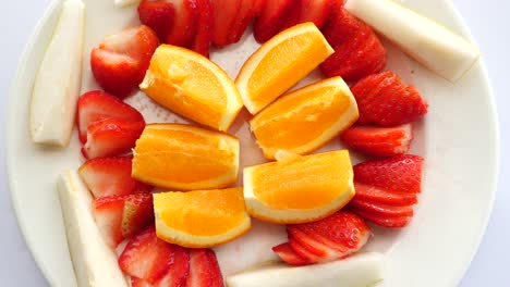 ripe red strawberries and orange fruit on a plate