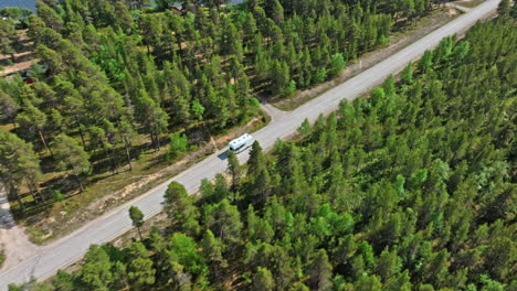 Vista-Aérea-De-Seguimiento-De-Una-Casa-Rodante-Conduciendo-En-El-Desierto-Polar-De-Inari,-Norte-De-Finlandia