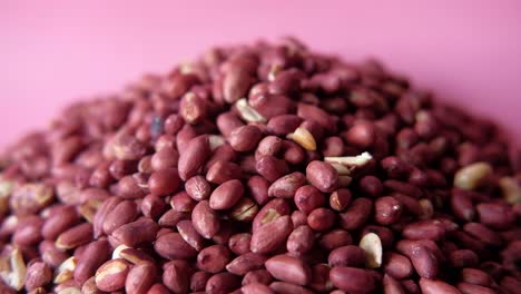 close-up of a pile of red peanuts on a pink background