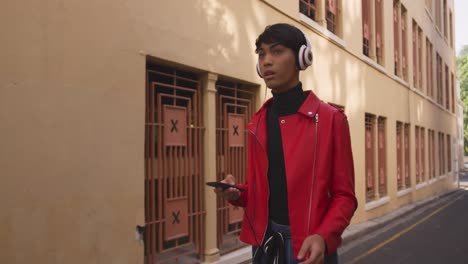 transgender adult listening to music in the street