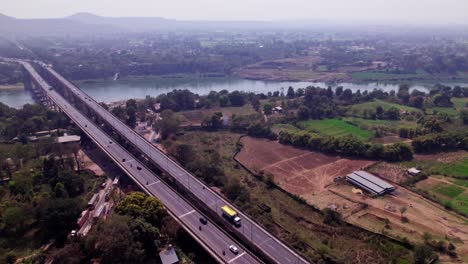 trees river bridge with haze and farming land, day time, push in, drone shot, 4k.