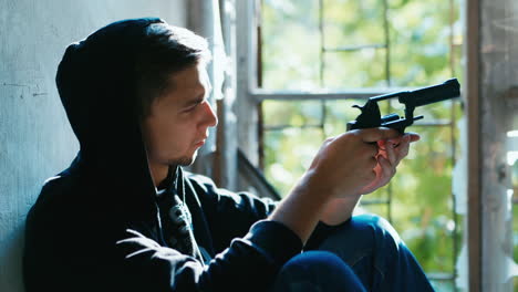 Teenager-with-a-gun-sits-in-an-abandoned-building-3