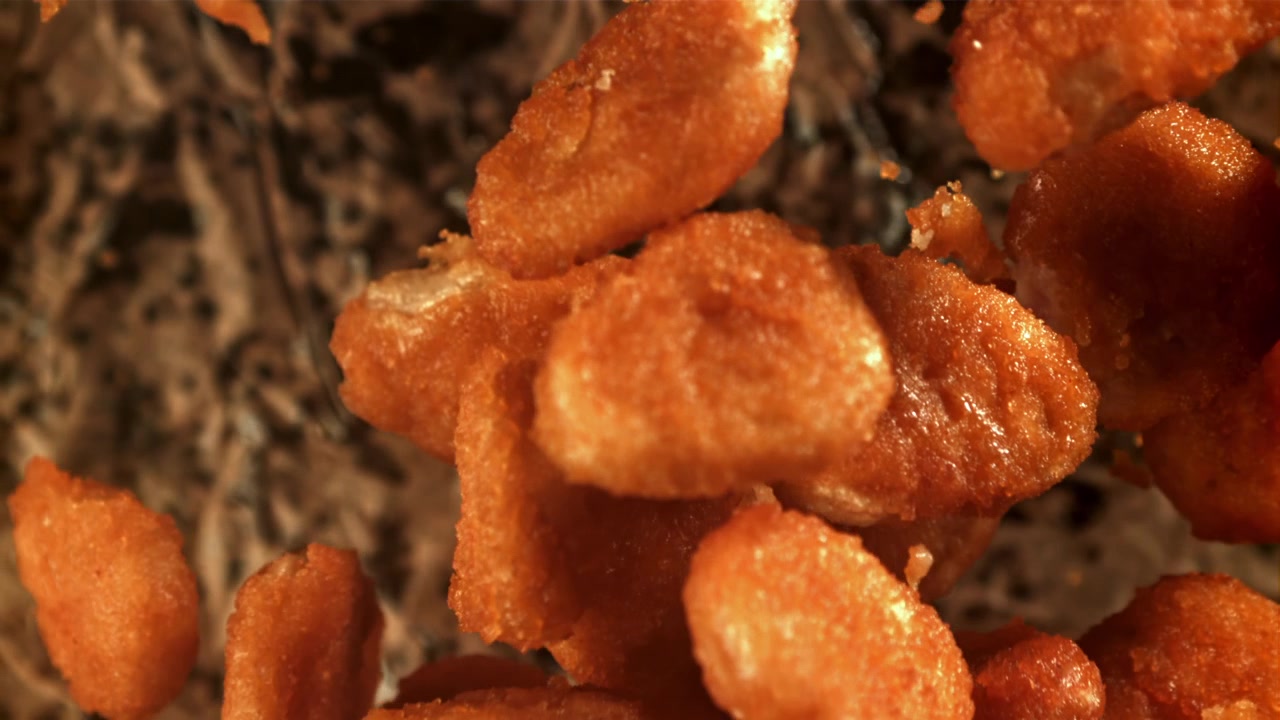 Nuggets di pollo croccanti che cadono al rallentatore.