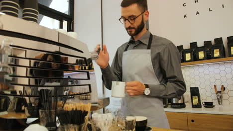 caucasian male barista working in modern coffee shop