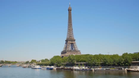 Boats-Docked-At-Seine-River-Near-a-Bridge-And-Eiffel-Tower-At-Paris,-France