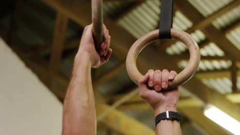 side view of a shirtless athletic caucasian man training at a gym