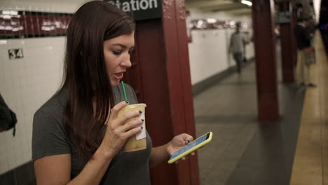 young attractive female waits for subway train to arrive at a new york subway station