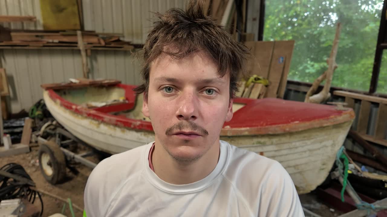 Worker puts on facemask respirator for fiberglass boat work