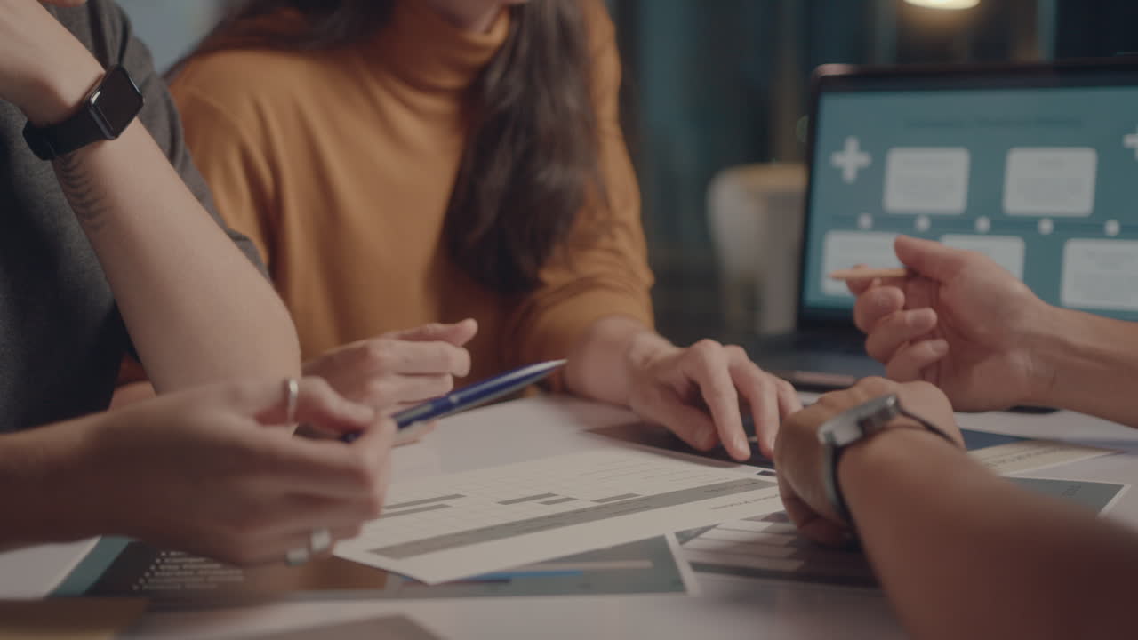Business Team Working with Papers during Night Meeting