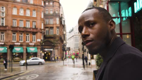 black male looking around a busy street in london