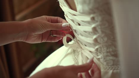 bridesmaid ties laces on wedding dress