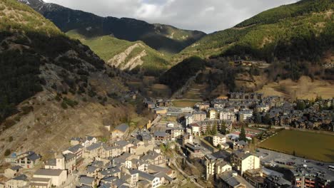 aerial perspective of andorran town in mountain valley with forest and fields. european alpine community, scenic travel and nature overview