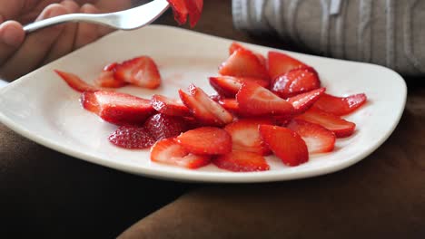 mujeres comiendo fresas rojas en un plato