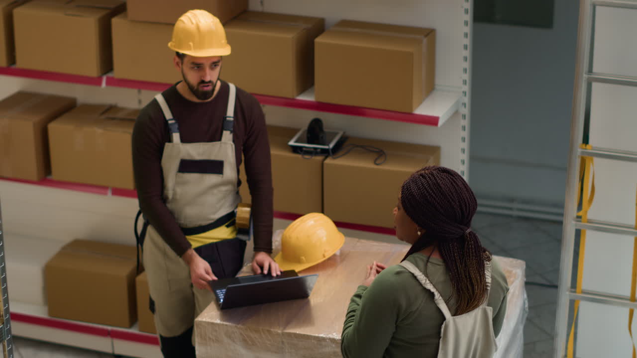 Warehouse employees working on inventory with laptop