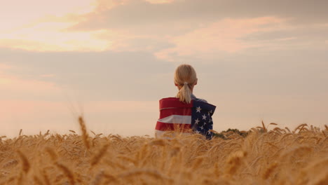 Bauer-Mit-USA-Flagge-Auf-Den-Schultern-Steht-In-Einem-Riesigen-Feld-Von-Reifem-Weizen