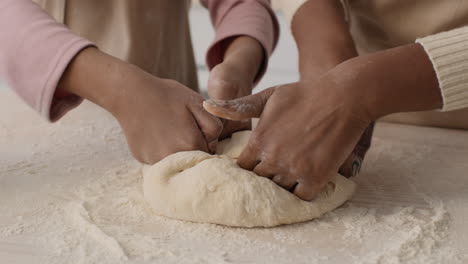 children and mother kneading dough