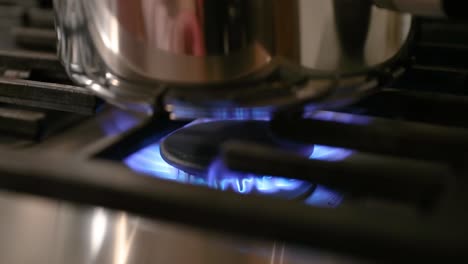 close up of stove pilot light turning on in slow motion