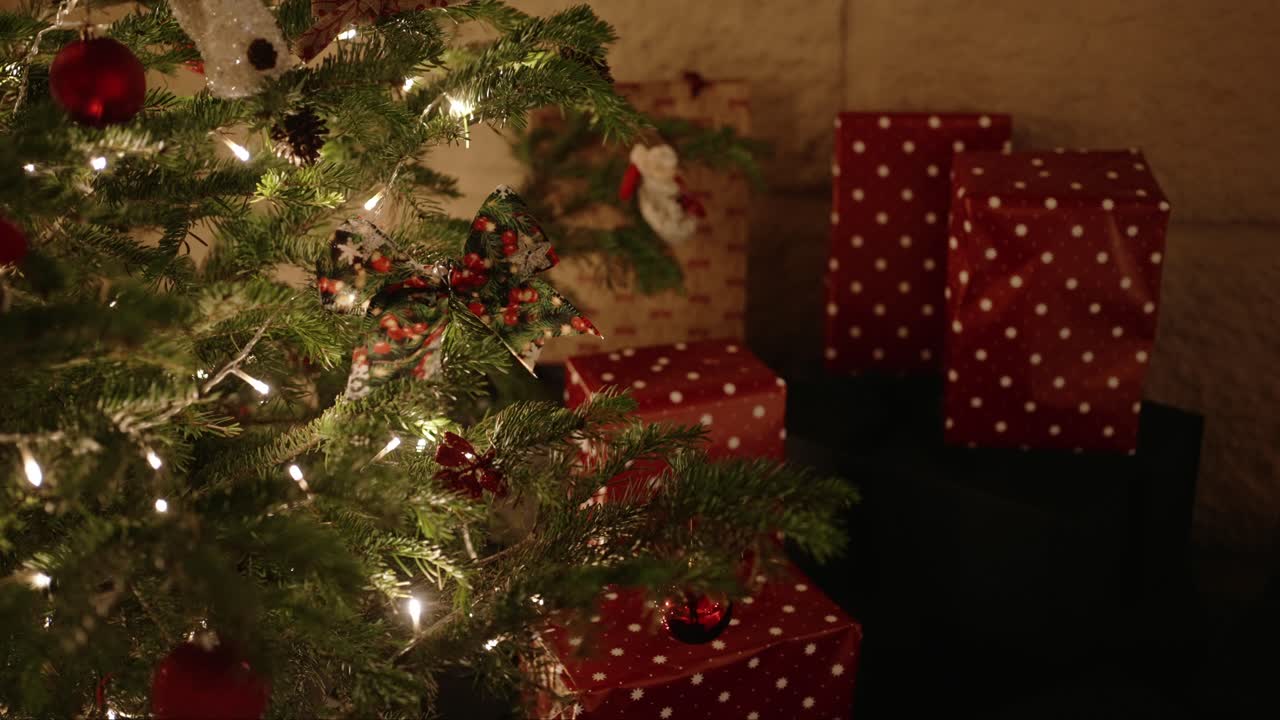 빨간색 활 장식물 과 폴카 도트 로 포장 된 선물 을 가진 크리스마스 트리