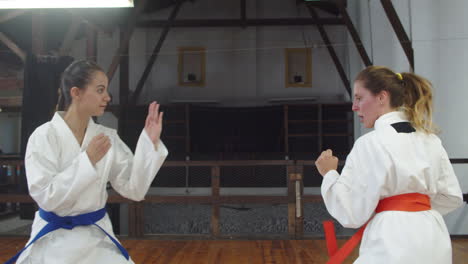 vista lateral de chicas en kimono inclinándose y comenzando a entrenar