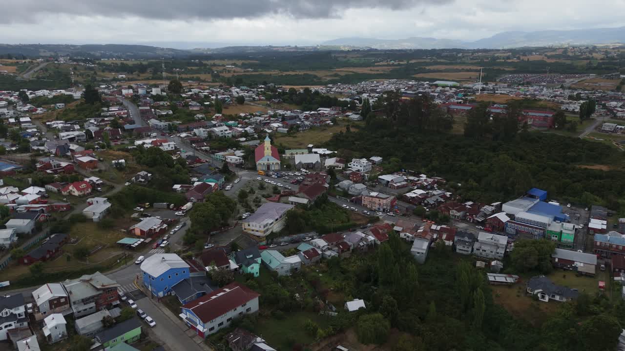 Drone capturing Chonchi, a charming town nestled in the picturesque landscapes of Chiloe Island, showcasing its vibrant architecture and the prominent church. orbit motion