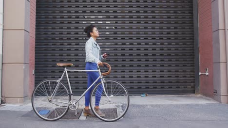 Mujer-De-Raza-Mixta-Caminando-Junto-A-Su-Bicicleta-En-La-Calle