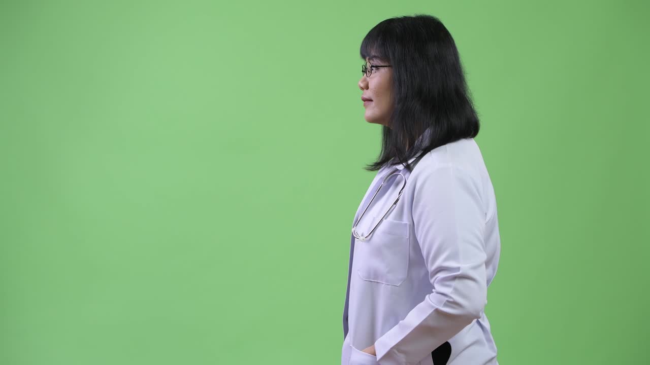 Profile view of beautiful happy Asian woman doctor