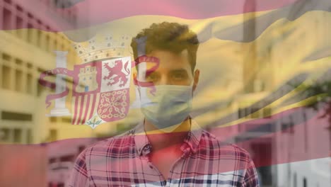 animation of flag of spain waving over man wearing face mask during covid 19 pandemic