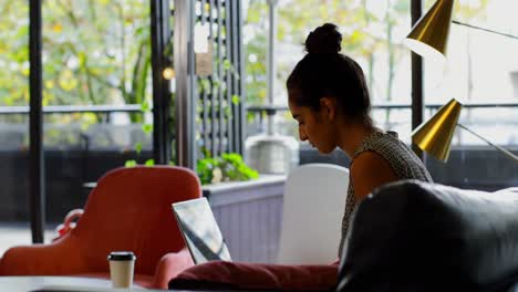 Side-view-of-young-caucasian-female-executive-working-on-laptop-in-modern-office-4k