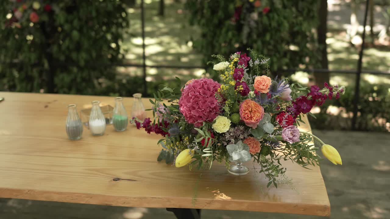 Elegant floral arrangement with vibrant flowers on a rustic wooden wedding table