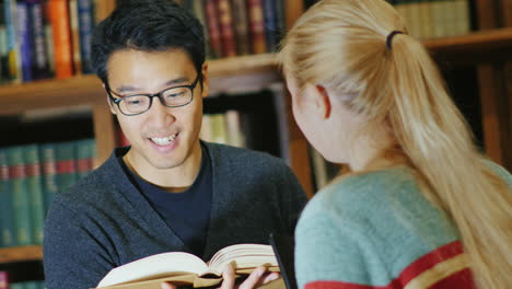 hombre coreano sonriente hablando con una mujer en la biblioteca 2