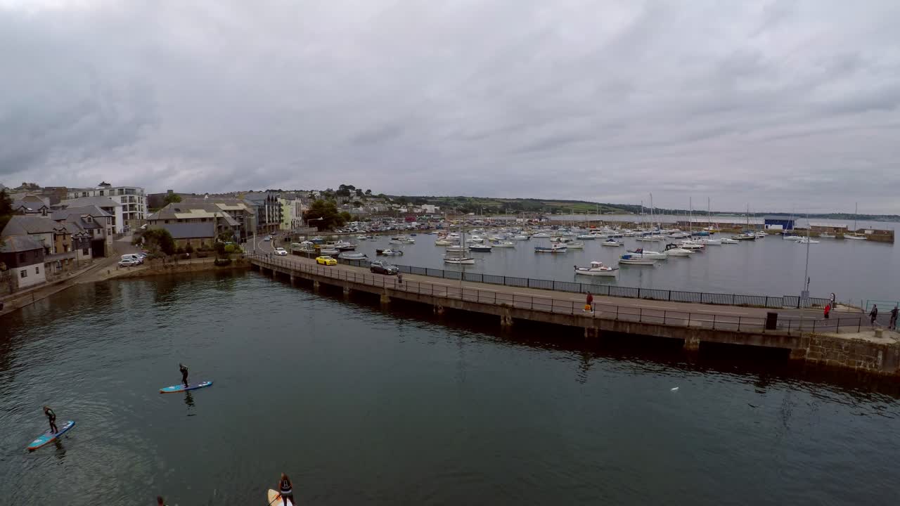 imágenes aéreas de personas remando en el puerto de penzance al atardecer por el puerto de penzance, muelle, barcos y yates en la hermosa y pintoresca zona de cornualles, popular entre los turistas