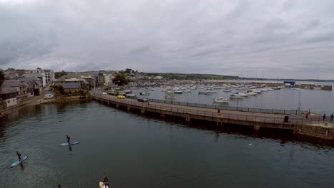 Imágenes-Aéreas-De-Personas-Remando-En-El-Puerto-De-Penzance-Al-Atardecer-Por-El-Puerto-De-Penzance,-Muelle,-Barcos-Y-Yates-En-La-Hermosa-Y-Pintoresca-Zona-De-Cornualles,-Popular-Entre-Los-Turistas