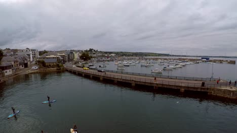 imágenes aéreas de personas remando en el puerto de penzance al atardecer por el puerto de penzance, muelle, barcos y yates en la hermosa y pintoresca zona de cornualles, popular entre los turistas