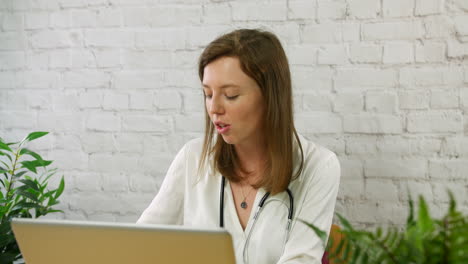 Un-Joven-Médico-De-Cabecera-Hablando-Con-Un-Paciente-En-Una-Reunión-De-Consulta-De-Cita-Virtual-En-Un-Consultorio-Médico