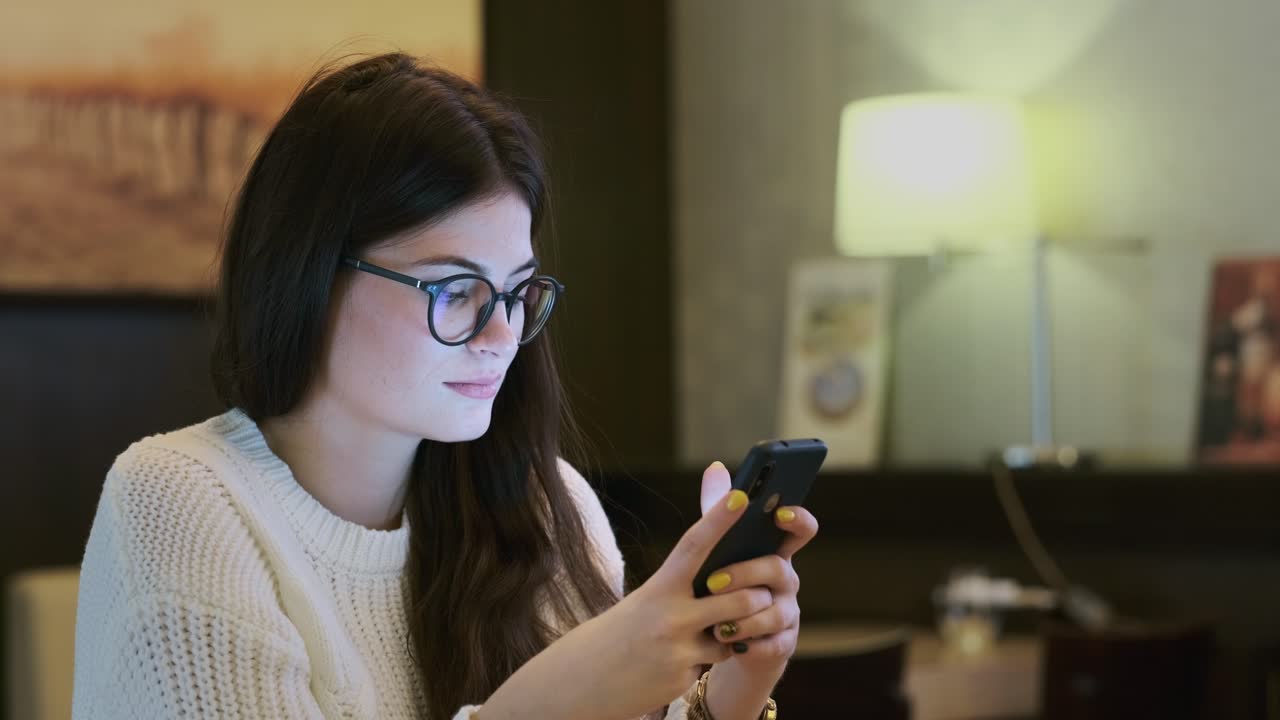 joven usando un teléfono inteligente en un café