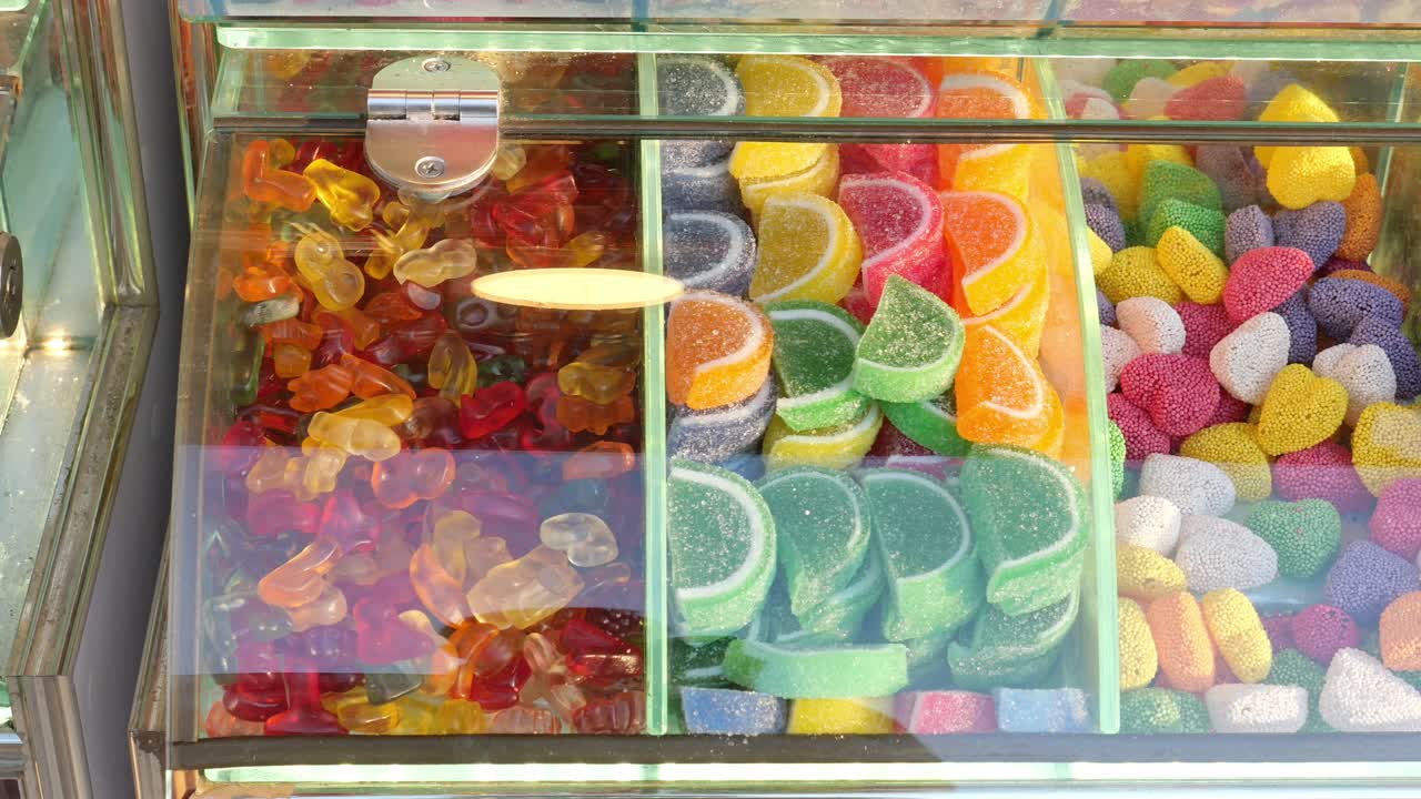 Colorful Assortment of Candies and Gummy Bears in Glass Case