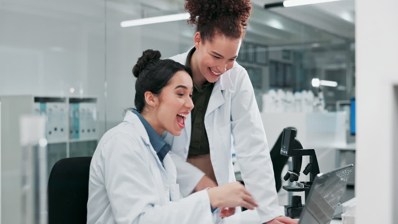 Due scienziate che lavorano insieme in un laboratorio, sorridenti ed entusiaste della loro ricerca