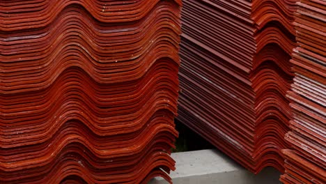 stacked red corrugated roofing tiles