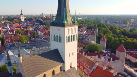 tower view of st. olaf's church, with aerial view of tallinn, estonia, city's historic architecture and vibrant landscape in background.