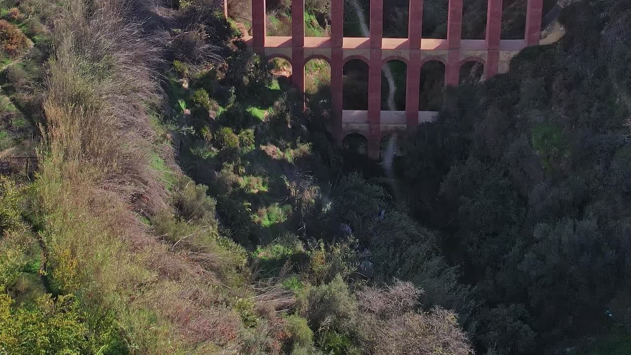 Acueducto del Águila escondido en un barranco verde